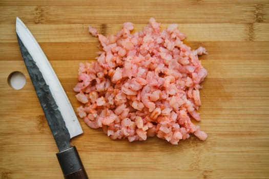 Overhead view of roughly chopped shrimps on cutting board