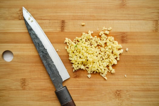 Overhead view of chopped ginger on cutting board