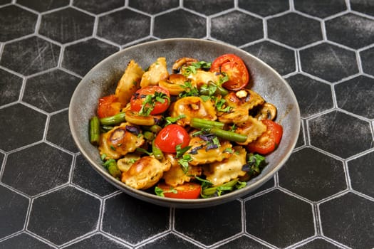 Fried ravioli with green beans, tomato and champignon mushrooms in a plate