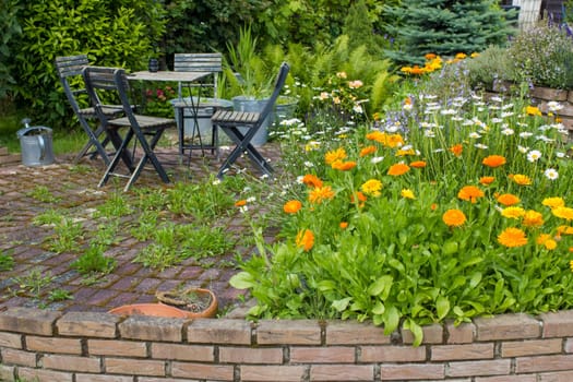 herb spiral in the garden with fresh herbs and flowers