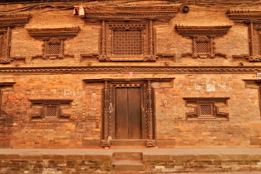Facade of a temple, palace with elaborate wood carvings on the windows and doors in the ancient city of Bhaktapur in the Kathmandu Valley, Nepal 2022