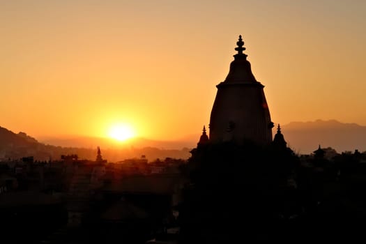 Sunset over Bhaktapur, the silhouette, contour of the Shilu, Silu Mahadeva, Mahadev Temple in front of the skyline of the old town, Bhaktapur, Nepal 2022