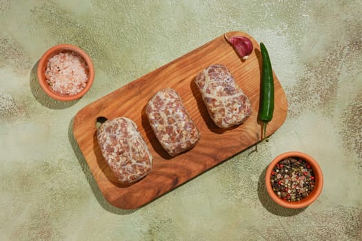 Overhead view of raw beef or lamb patties - Apkhazura on wooden chopping board