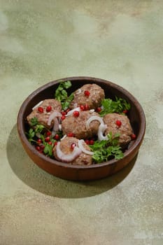 Georgian fried beef patties wrapped in fat gut - Apkhazura in clay pot decorated with pomegranate seeds, slices of red onion and cilantro