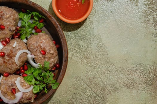 Traditional Georgian fried beef cutlets - Apkhazura in clay pot and adjika bowl with copy space