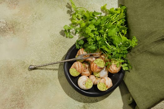 Overhead view of Escargot snails baked in sauce and filled with herbal spicy butter on a plate