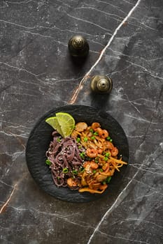 Overhead view of plate with black pasta with spicy seafood