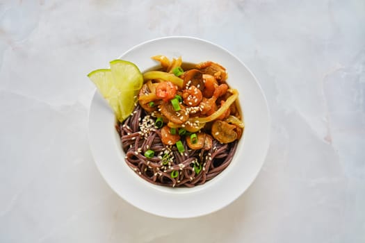 Overhead view of spicy black rice noodles with shrimps and mushrooms