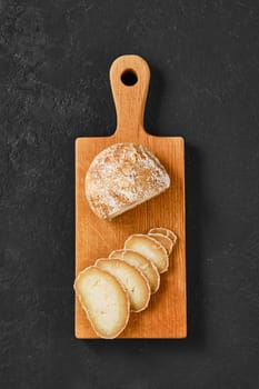 Overhead view of wooden chopping board with traditional Georgian cheese Dambalkhacho