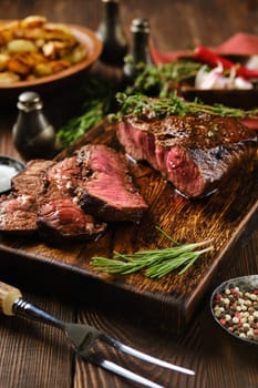 Juicy grilled top blade beef steak on wooden cutting board