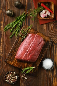 Close-up view of raw fresh beef flat iron steak on wooden kitchen table