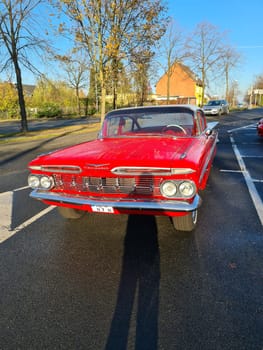 VELBERT, NRW, GERMANY - NOVEMBER 10, 2020: Rear view of a red colored 1960 Chevrolet Impala in a public parking lot