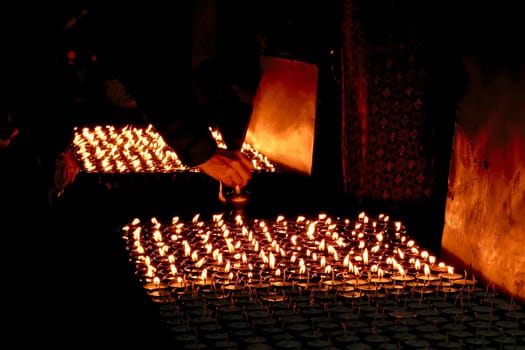 Many butter lamps, candles enlighten the darkness at the Boudhanath Stupa in Kathmandu, Nepal 2022