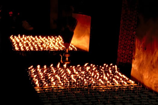 Many butter lamps, candles burning at night at the Boudhanath Stupa in Kathmandu, Nepal 2022