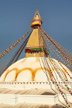 View onto the upper part of the Boudhanath Stupa, many colorful prayer flags are attached to it, Kathmandu, Nepal 2022