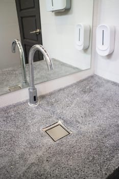 Touchless tap in public toilet and restroom, stock photo
