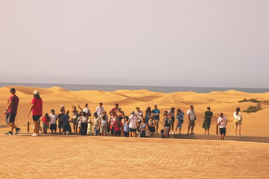 Gran Canaria, Spain, Canary Islands, Playa del Inglés - JUL 17, 2024. Tourist at a viewpoint of Dunes de Maspalomas. Maspalomas Dunes Nature Reserve.
