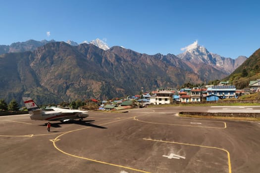 The airfield, landing field of the Hillary-Tenzing Airport, Lukla Airport, a small plane, aircraft is waiting for take off, Kongde Ri peak in the background, Mount Everest Base Camp Trek, EBC, Nepal 2022