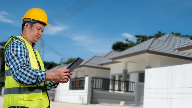 Engineer architect with protective helmet working at house building on construction site background, Housing projects, Residential construction projects.