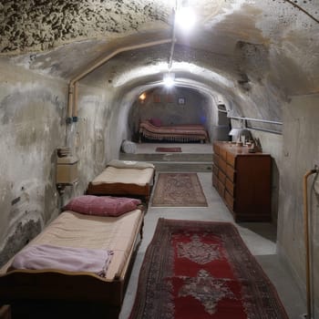 A subterranean bunker's interior, with its stark and functional design, stands ready for an emergency. The space is a testament to survival instinct and the need for security in uncertain times