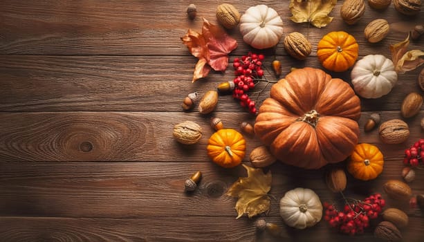 Pumpkins, nuts, colorful berries and leaves on an old wooden table. Autumn seasonal background top view. Halloween and thanksgiving holiday conceptual texture with copy space