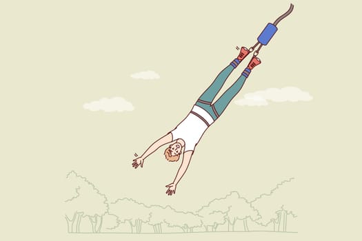Man gets addicted to bungee jumping, enjoying extreme sport that releases adrenaline into blood. Guy who is fan of bungee jumping flies down from tall building or bridge and smiles, looking at screen