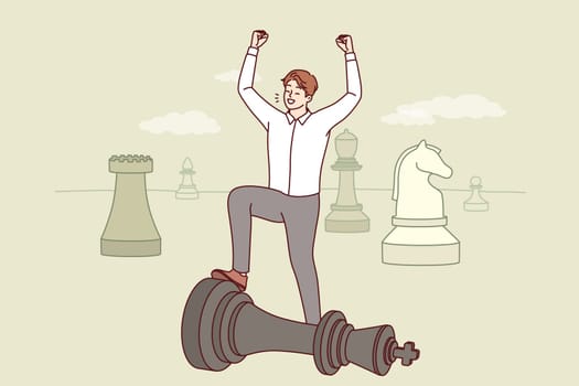 Man business strategist celebrates victory over competitor located on giant chessboard. Successful Strategist manager is proud of defeat of enemy, is hindering growth of corporate profits.