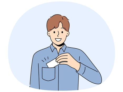 Man takes out business card from pocket to exchange contacts with potential partner or buyer and looks into camera with smile. Business guy in blue shirt wants to share contacts with new acquaintances