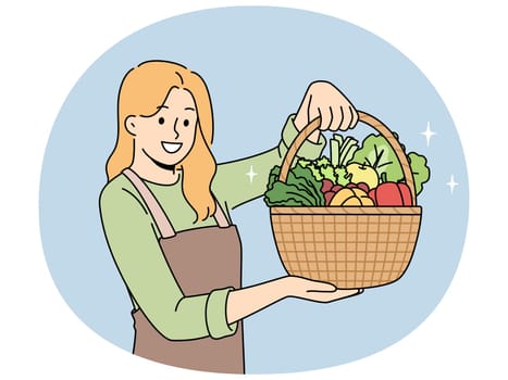 Woman farmer with basket full of vegetables recommends eating natural organic food grown without pesticides. Beautiful girl farmer in apron works as seller in vegetable shop with useful products
