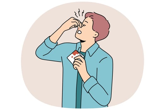 Man pinches bleeding nose and holds bloody handkerchief due to high blood pressure. Young guy with broken nose tries to stop bleeding after fighting and getting punched in face or head