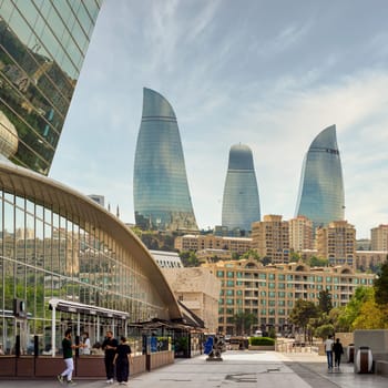 Baku, Azerbaijan - May 10, 2024: Deniz Mall showcases modern architecture with the Flame Towers rising majestically in the background, illustrating Baku vibrant skyline