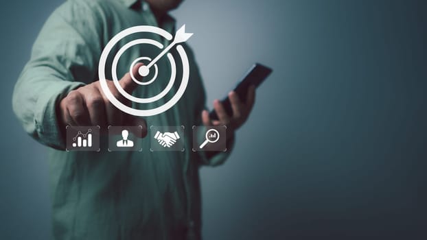 Businessman use smartphone with virtual target icon for strategic planning to business growth and target customer group, business objective,Targeting business concept, Business goal.