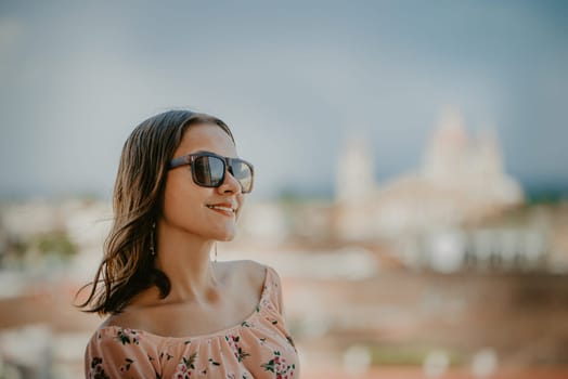 Portrait of a smiling girl in glasses with blurred background of the cathedral of Granada Nicaragua. Tourism concept