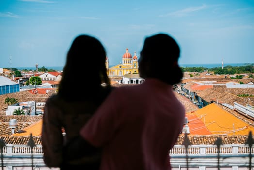 Silhouette of tourist couple looking at the Granada cathedral from the La Merced viewpoint