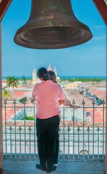 Tourist couple at the viewpoint of the La Merced church looking at the Granada cathedral. Young tourist looking at the Granada cathedral from the La Merced viewpoint