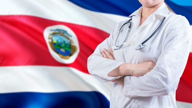 Healthcare concept with Costa Rica flag in background. Female doctor with crossed arms with Costa Rican flag in the background