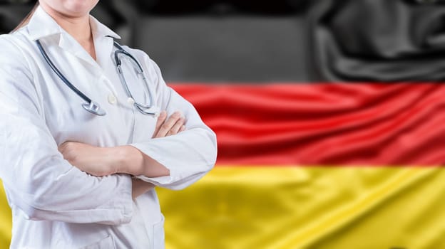 Female doctor with arms crossed with German flag in the background. Healthcare concept with Germany flag in background