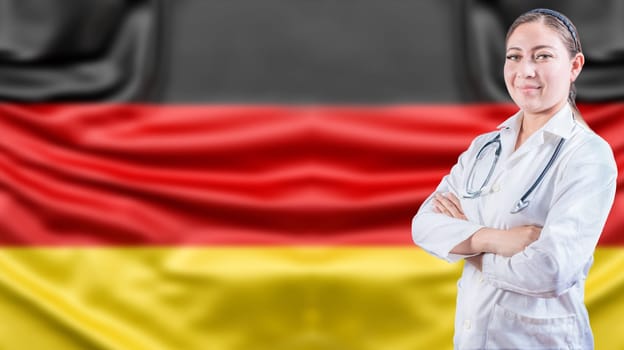 Portrait of female doctor with arms crossed with German flag background. Healthcare concept with Germany flag in background