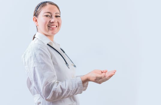 Beautiful smiling female doctor showing an advertisement with palms. Happy female doctor presenting something with palms