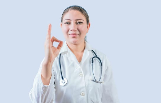 Beautiful female doctor gesturing approval isolated. Smiling female doctor approving and recommending isolated