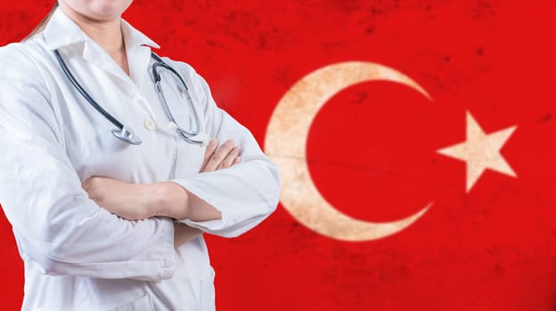 Healthcare concept with Turkish flag in background. Portrait of doctor with crossed arms with Turkish flag in the background