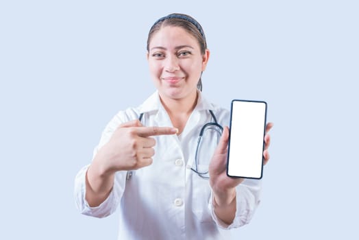 Female doctor showing and pointing an advertisement on the smartphone screen isolated. Smiling female doctor pointing an app on the phone screen