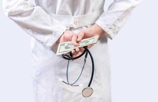Corrupt doctor hiding money back, Dishonest doctor hiding money. Medical corruption and bribery concept