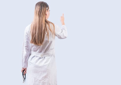 Rear view of female doctor pointing isolated. Young female doctor from behind pointing finger isolated