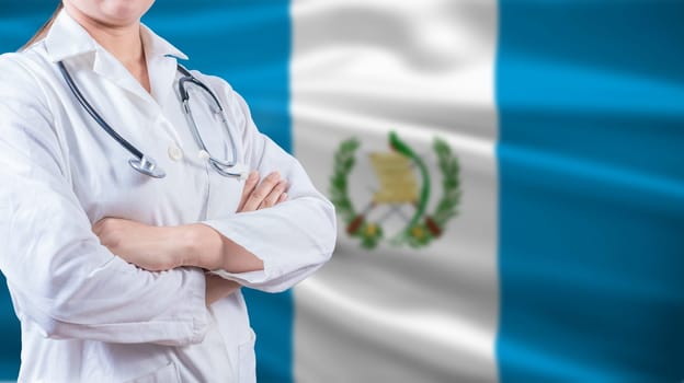 Healthcare concept with Guatemalan flag in background. Doctor with arms crossed with Guatemala flag background