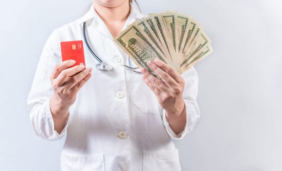 Female doctor hands holding credit card and money isolated. Unrecognizable doctor holding money and credit cards isolated