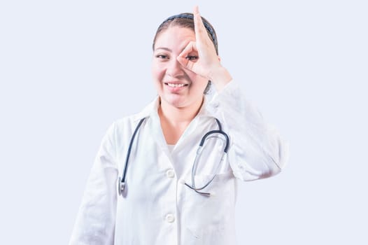 Cheerful female doctor gesturing approval isolated. Young female doctor approving with finger on isolated background