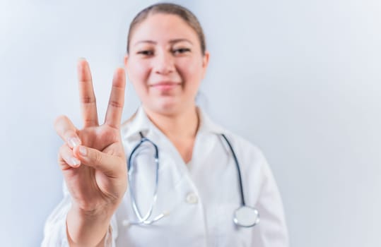 Female doctor counting number TWO isolated. Young female doctor counting number 2 on isolated background