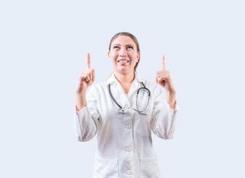 Happy female doctor pointing a promotion up. Smiling female doctor looking and pointing up isolated