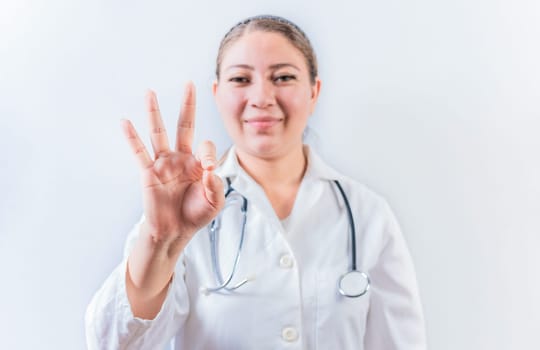 Female doctor counting number THREE isolated. Young female doctor counting number 3 on isolated background